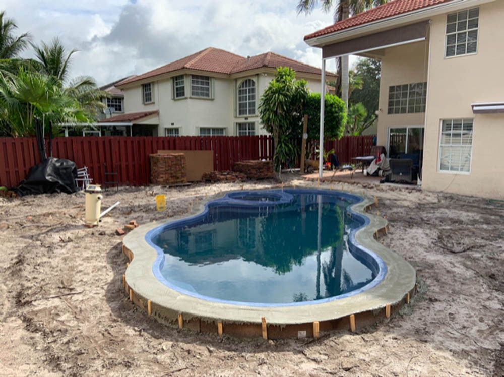 A swimming pool is being built in the backyard of a house.