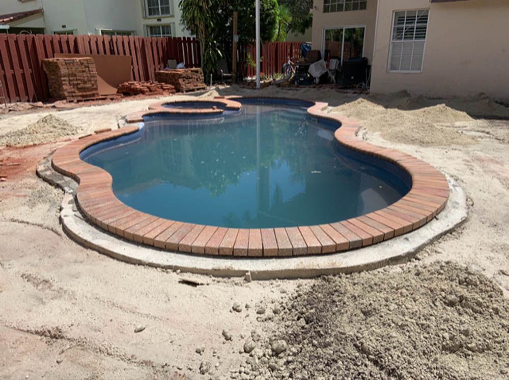 A swimming pool is being built in the backyard of a house.