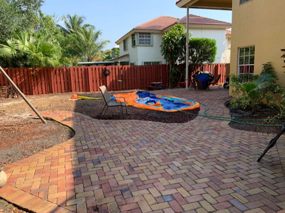 A backyard with a brick walkway and a pool