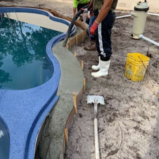 A man wearing white boots is working on a swimming pool