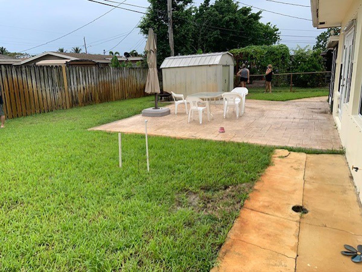 A backyard with a table and chairs and a shed.