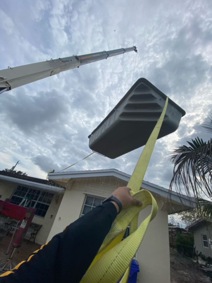 A person is lifting a swimming pool with a crane.