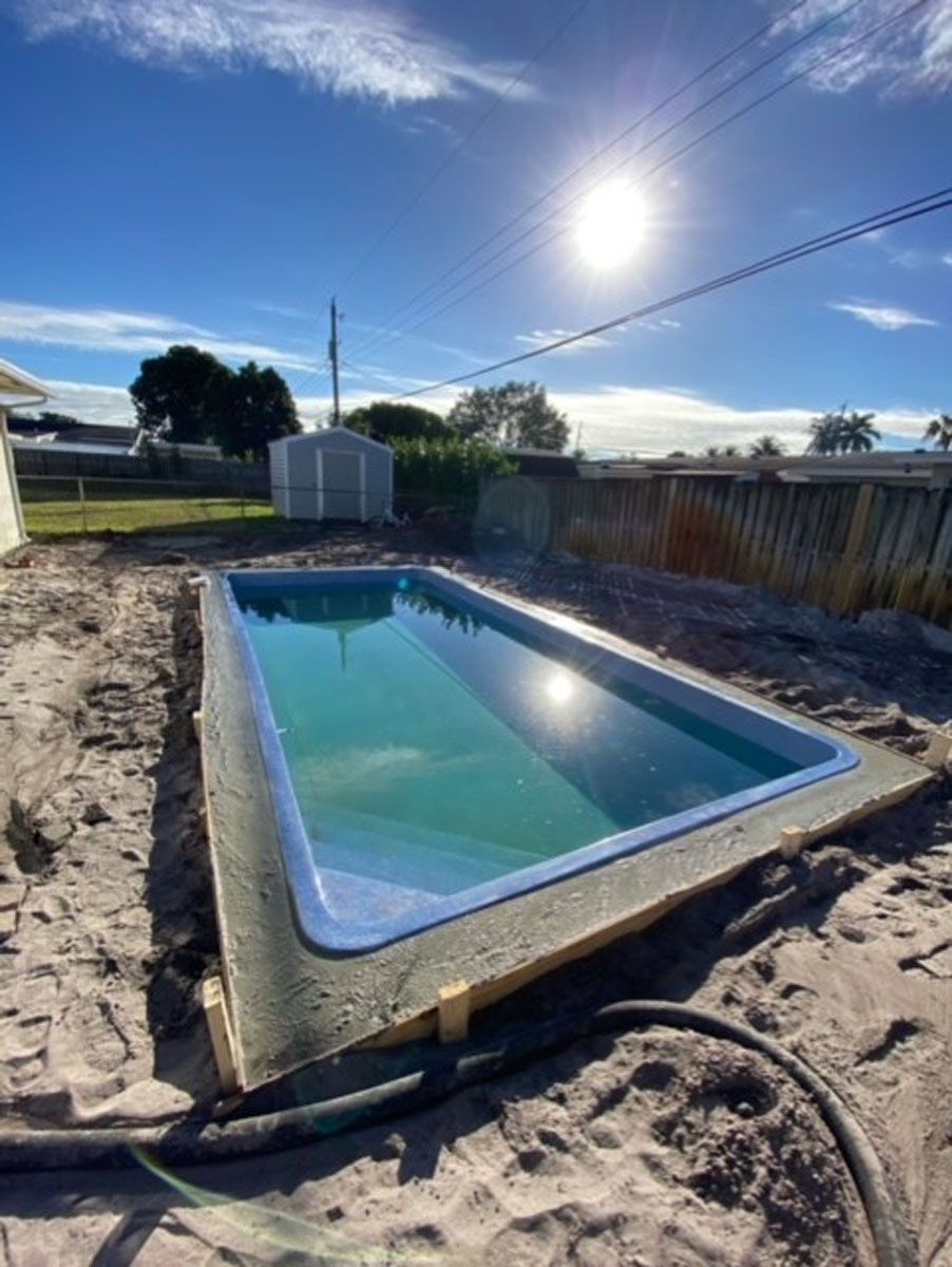 A swimming pool is being built in the backyard of a house.