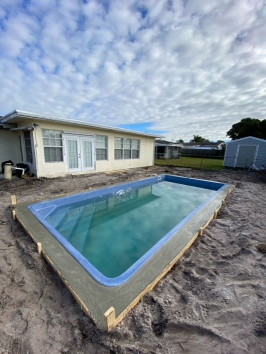A swimming pool is being built in front of a house.