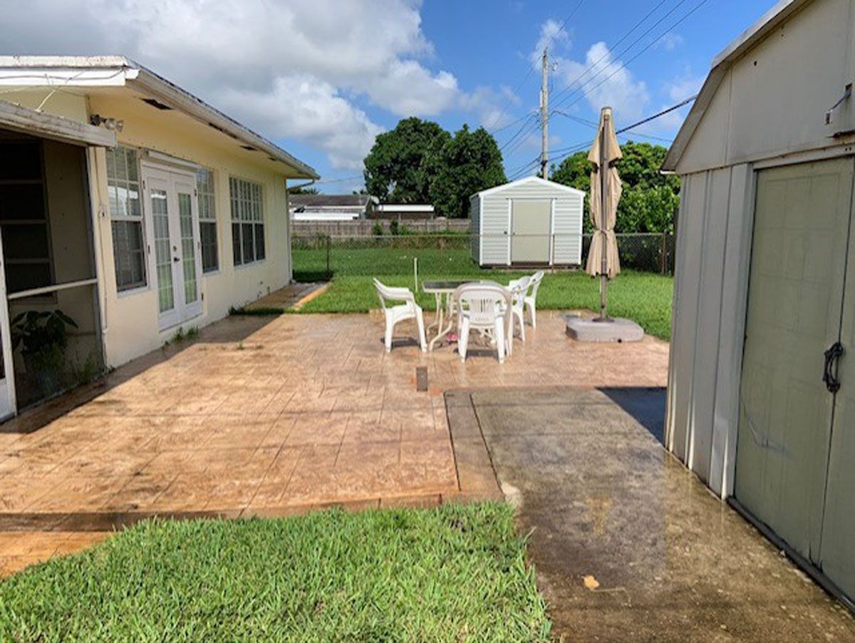 A backyard with a table and chairs and a shed.