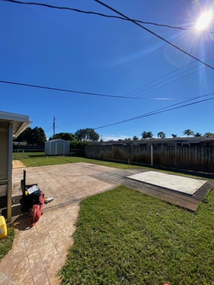 A backyard with a concrete driveway and a fire hydrant