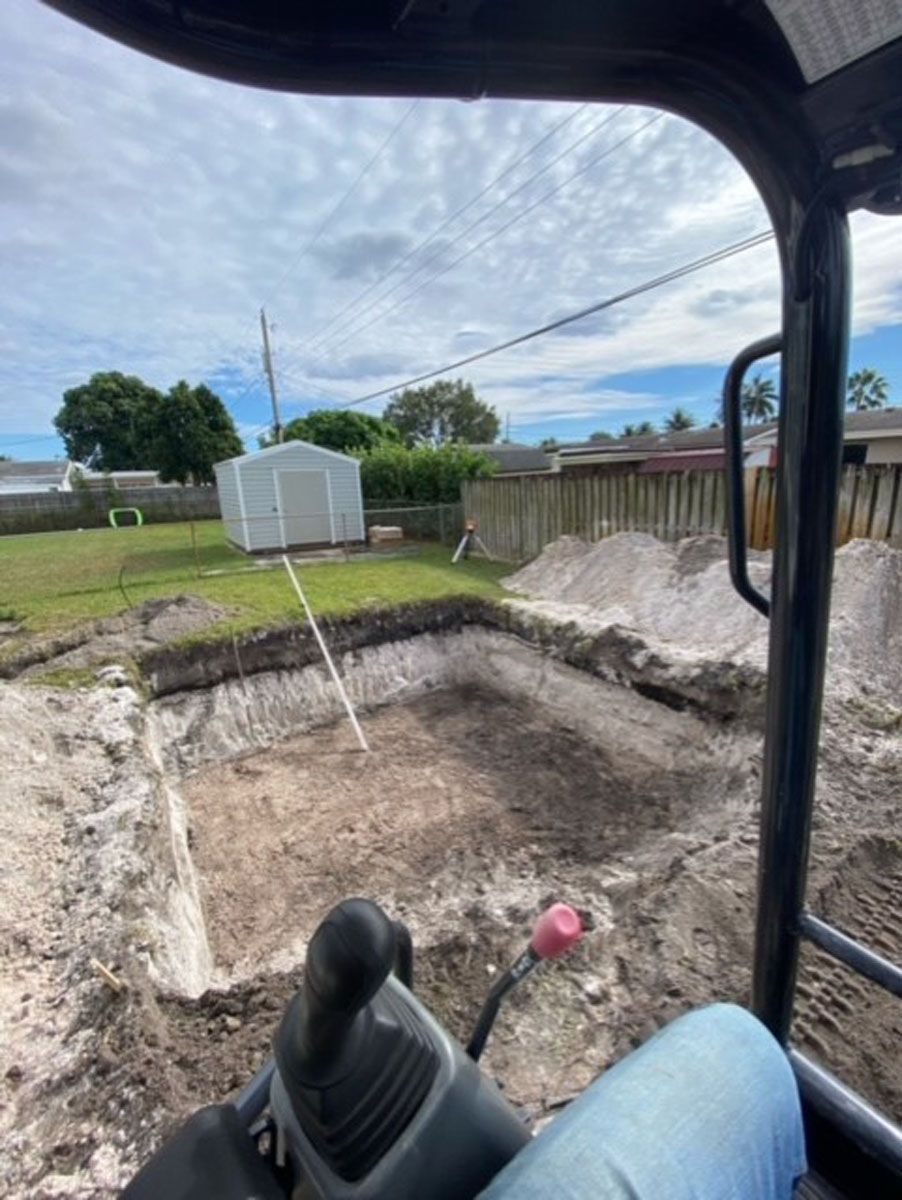 A person is driving a bulldozer on a dirt road.