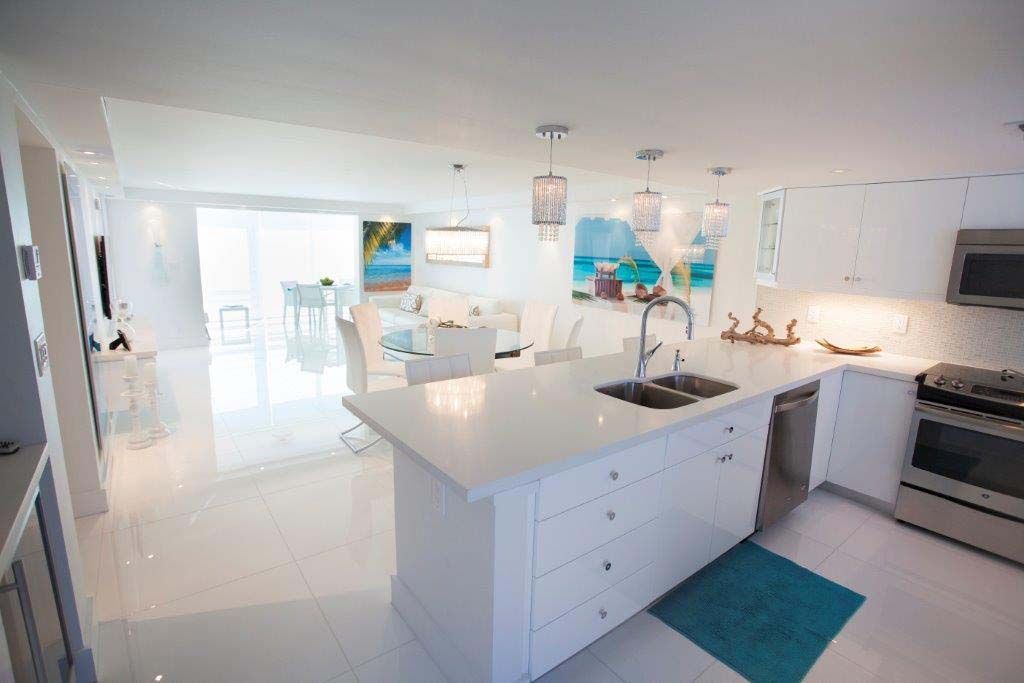 A kitchen with white cabinets and a large island in the middle.