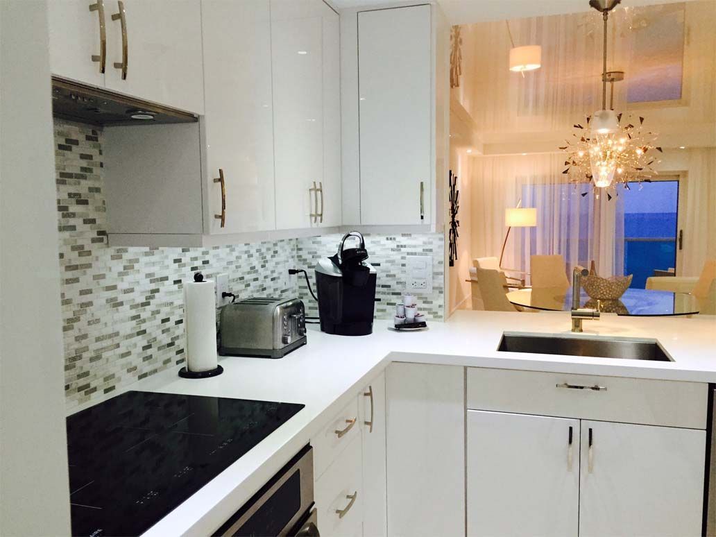 A kitchen with white cabinets and a black stove top oven