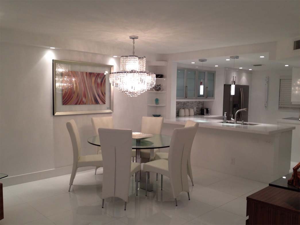A dining room with a table and chairs and a chandelier