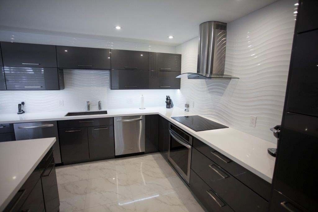 A kitchen with black cabinets and white counter tops