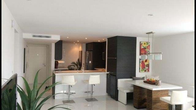 A living room with a table and chairs and a kitchen