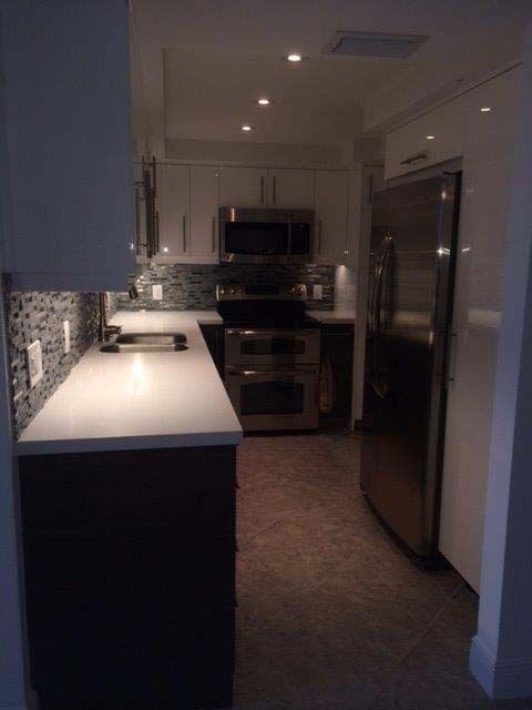 A kitchen with stainless steel appliances and white cabinets