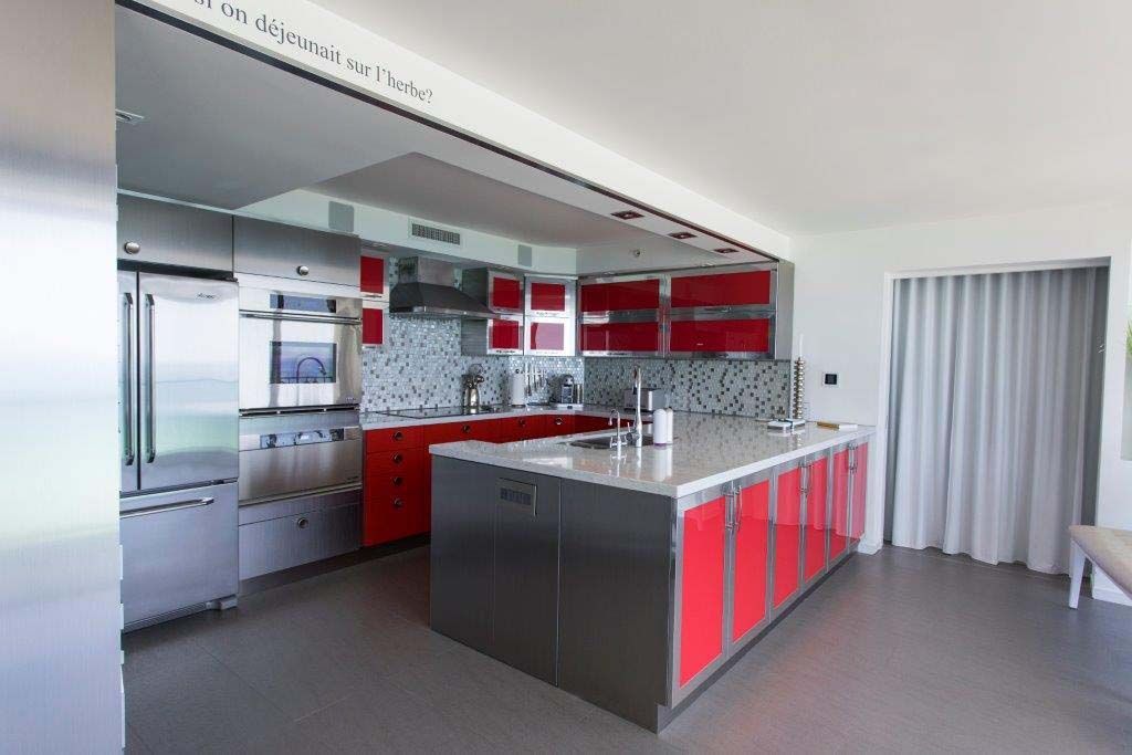 A kitchen with red cabinets and stainless steel appliances