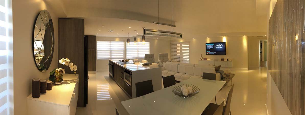A panoramic view of a dining room and kitchen in a house.