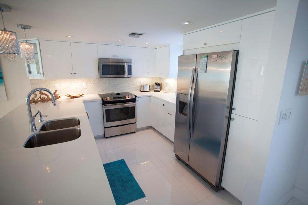 A kitchen with stainless steel appliances and white cabinets.