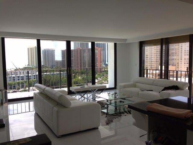 A living room with a lot of windows and a balcony
