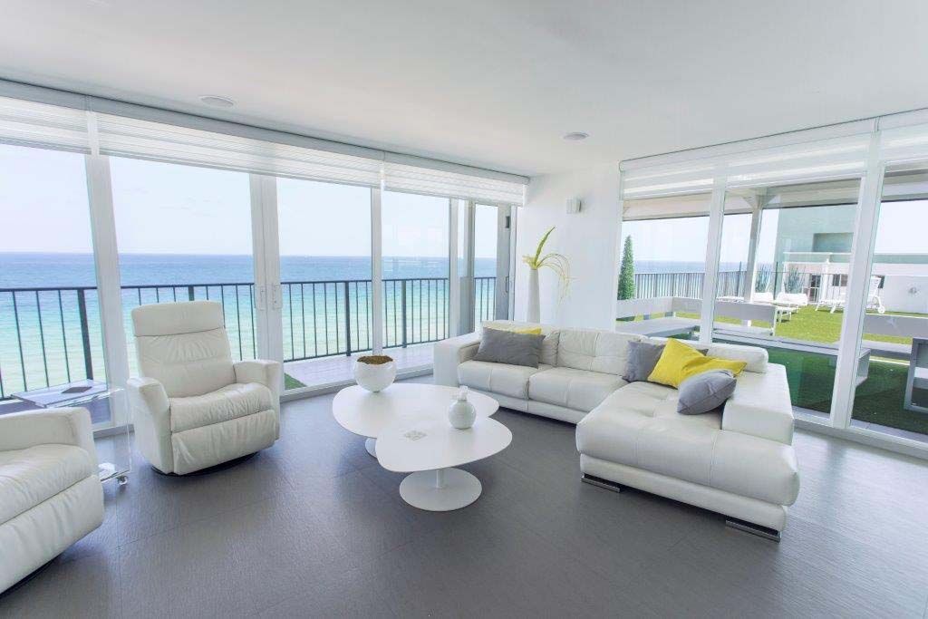 A living room filled with furniture and a view of the ocean.
