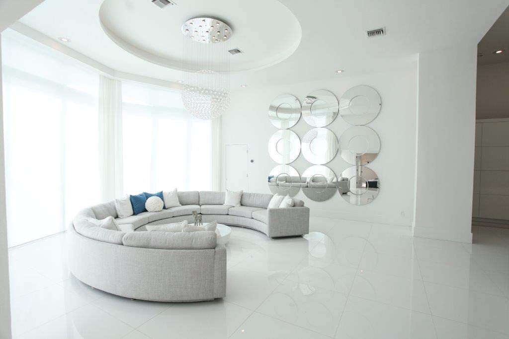 A living room with a curved sectional couch and a large window.