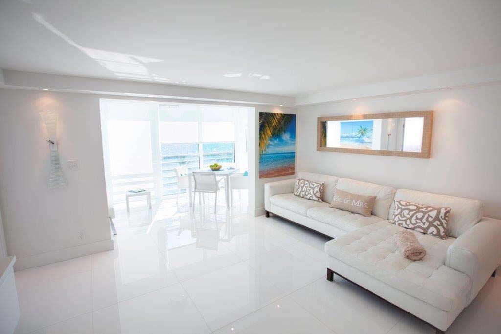 A living room with a white couch and a painting on the wall