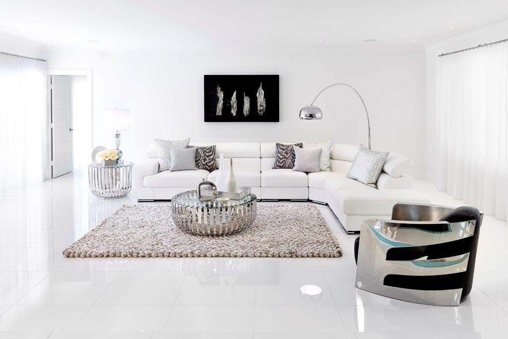 A living room with a couch , chair , coffee table and rug.