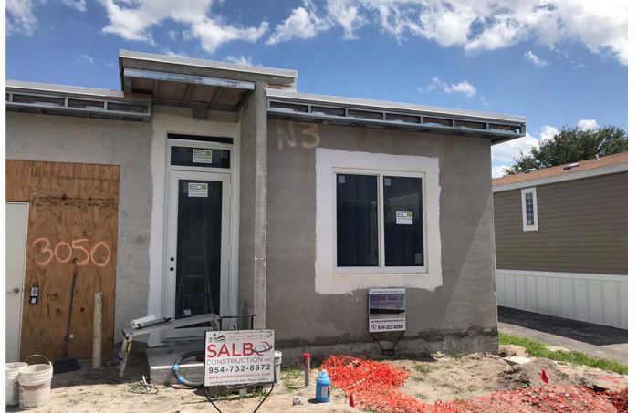 A house that is being built with a for sale sign in front of it.