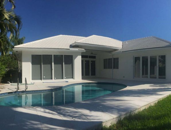 A white house with a swimming pool in front of it