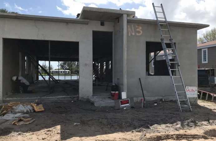 A ladder is sitting in front of a house under construction.