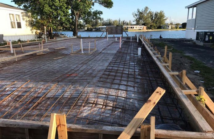 A concrete foundation is being built in front of a house.