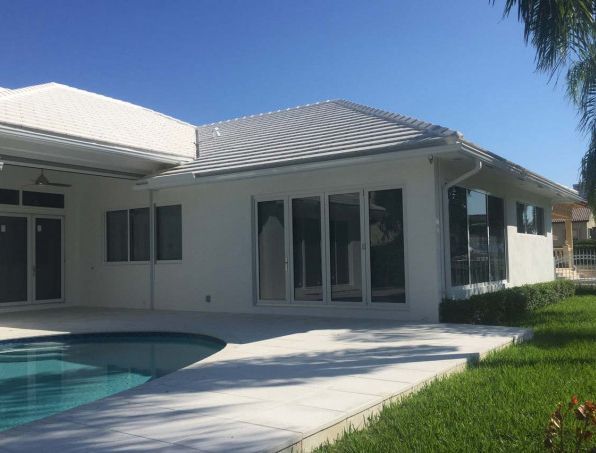 A white house with a swimming pool in front of it