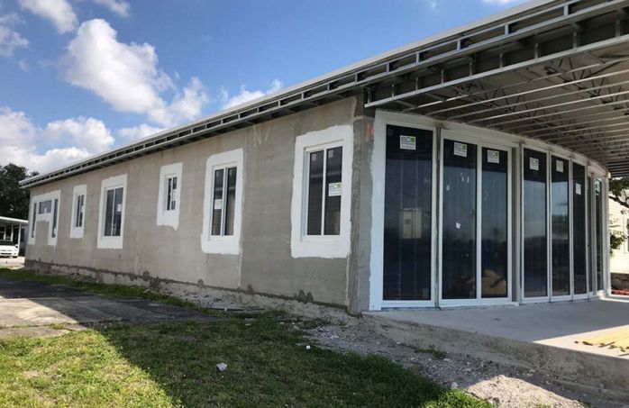 A large building with a lot of windows and doors is being built.