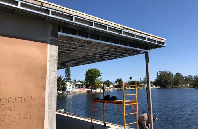 A building under construction next to a body of water.