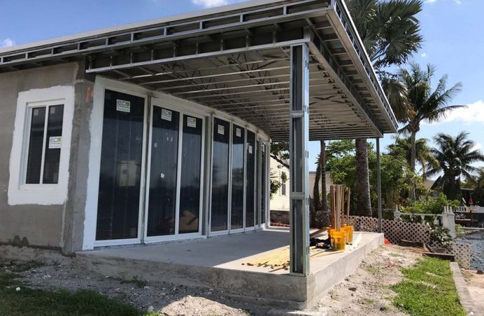 A house under construction with a lot of windows and a porch.