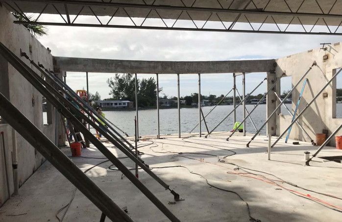 A building under construction with a view of a body of water.