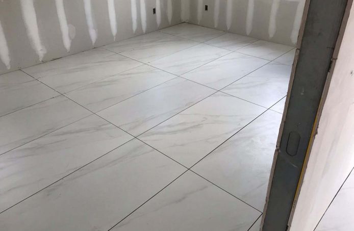 A room with white tiles on the floor and walls.