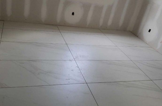 A room with white tiles on the floor and walls.