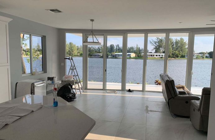 A living room with a lot of windows overlooking a lake.