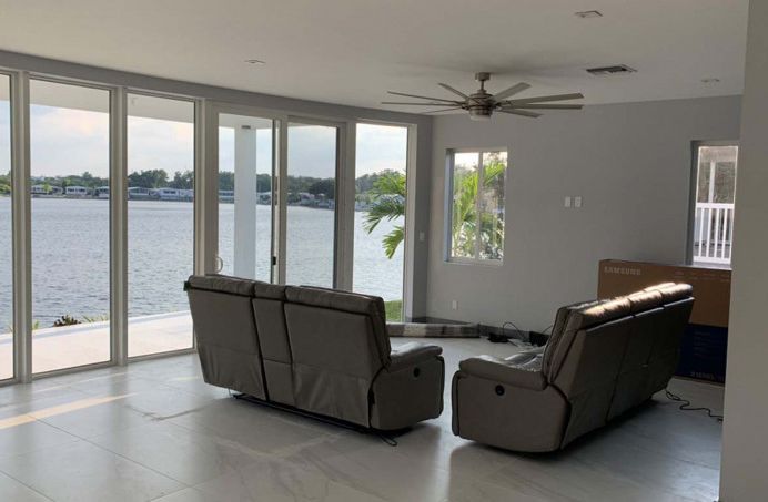 A living room with a couch and chairs and a view of the water.