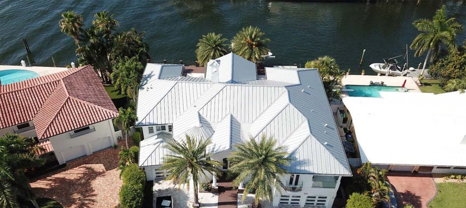 An aerial view of a house next to a body of water.