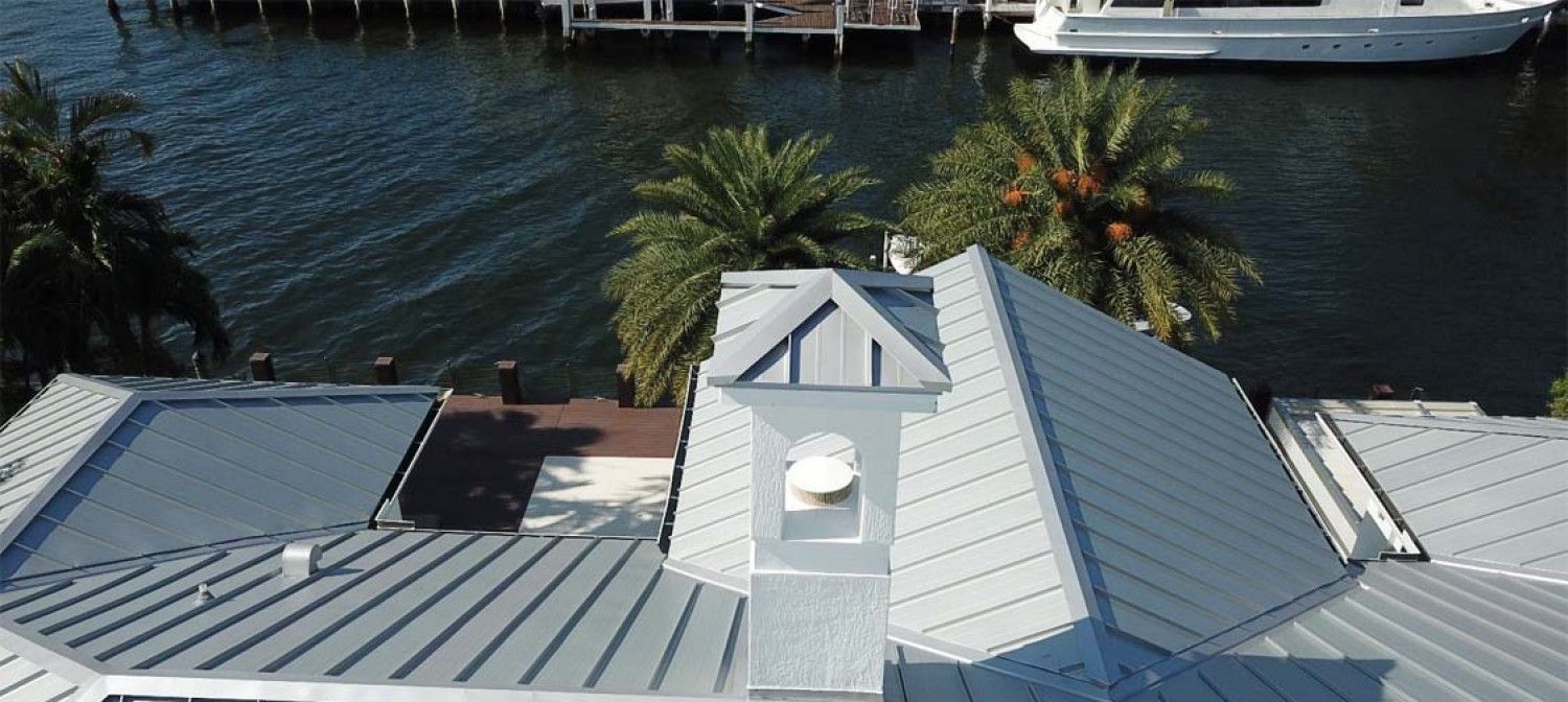 An aerial view of a house with a boat in the water.