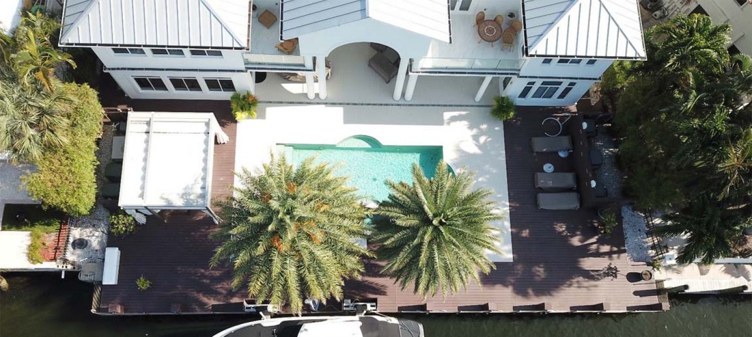 An aerial view of a house with a pool and palm trees.