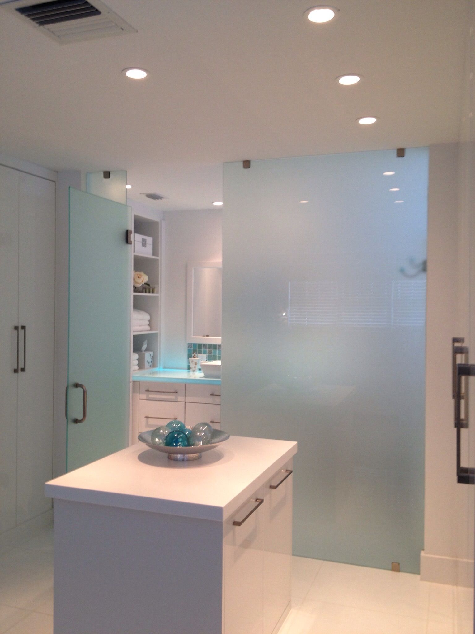 A kitchen with white cabinets and a glass door