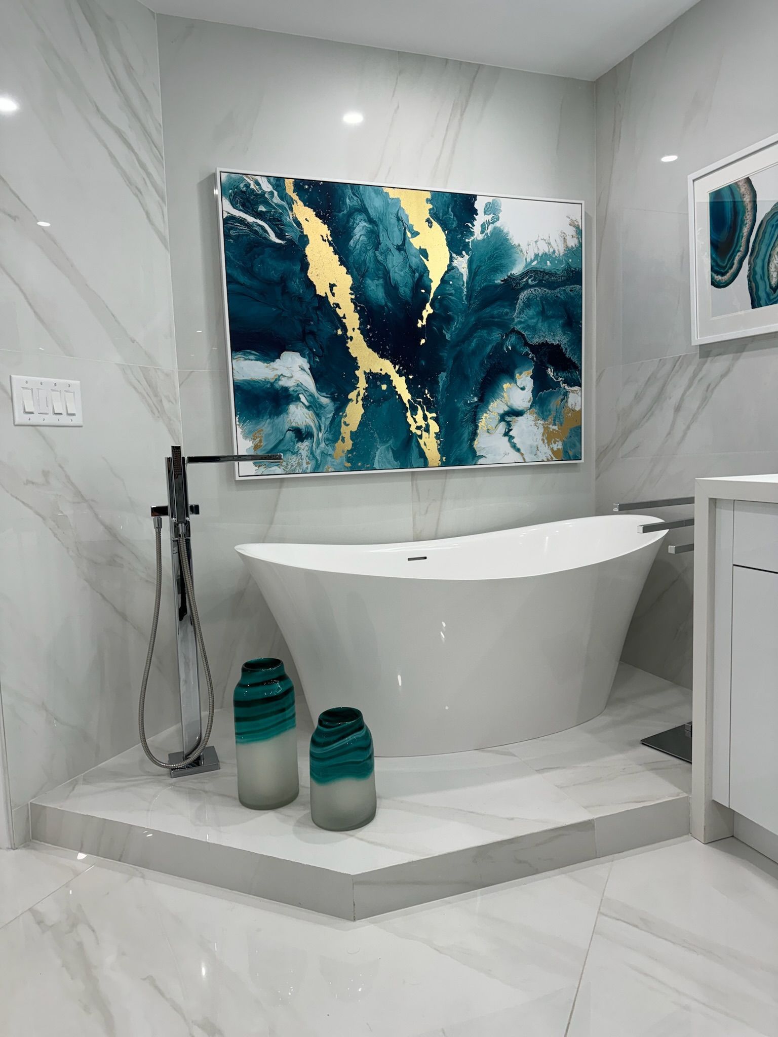 A bathroom with a bathtub and a painting on the wall.