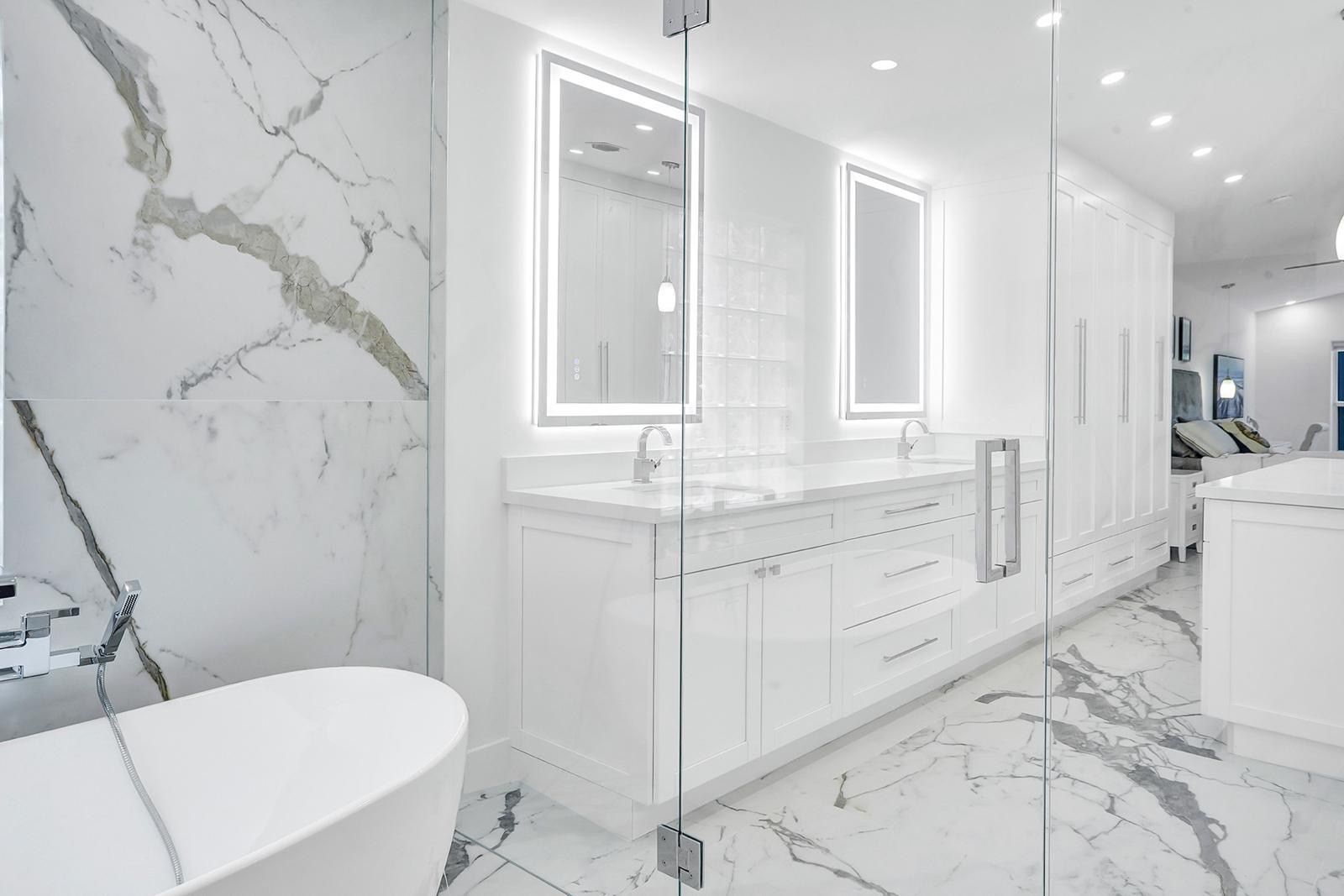 A bathroom with a bathtub , sinks , mirrors and marble floors.