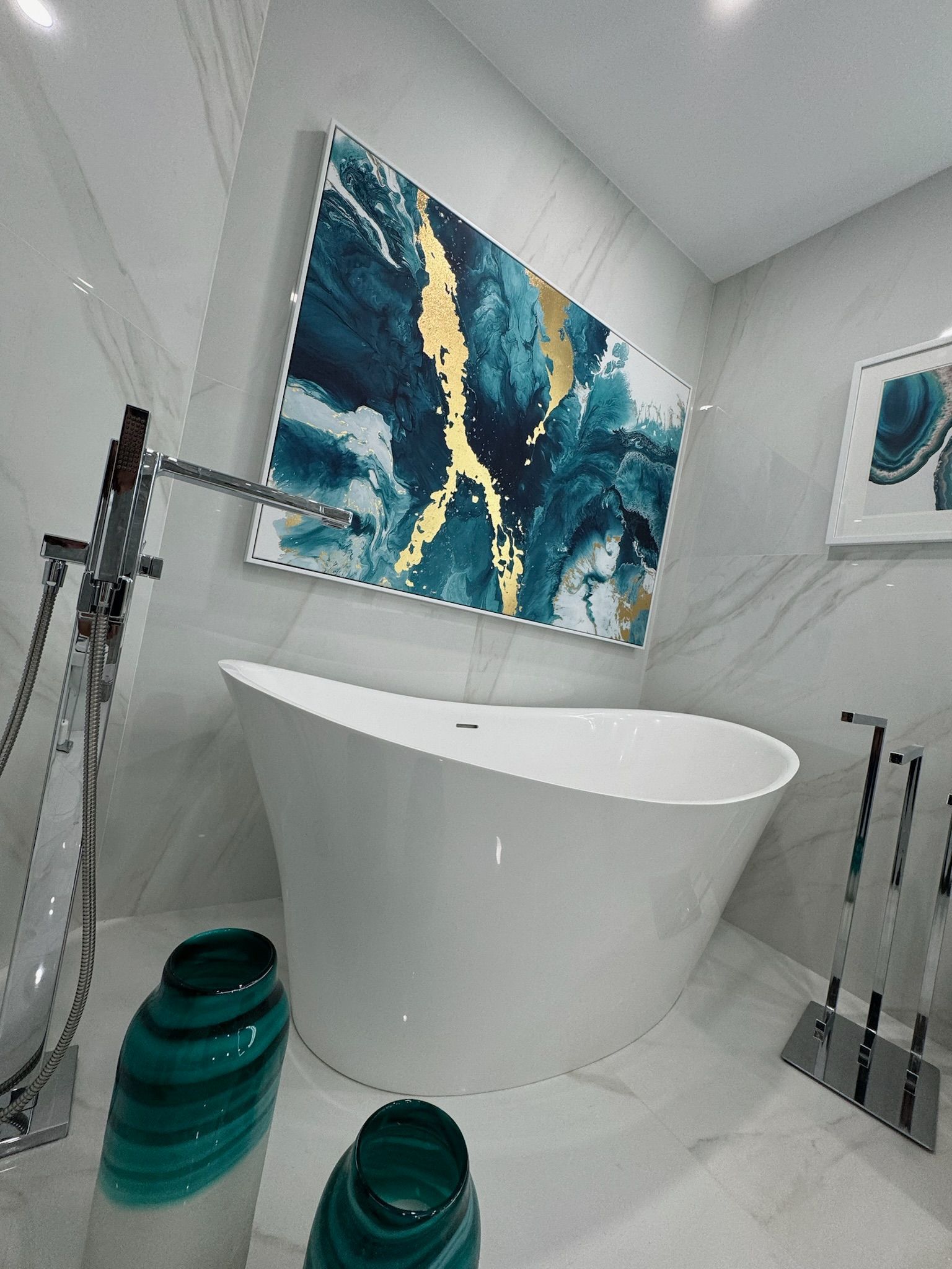A bathroom with a bathtub and a painting on the wall.