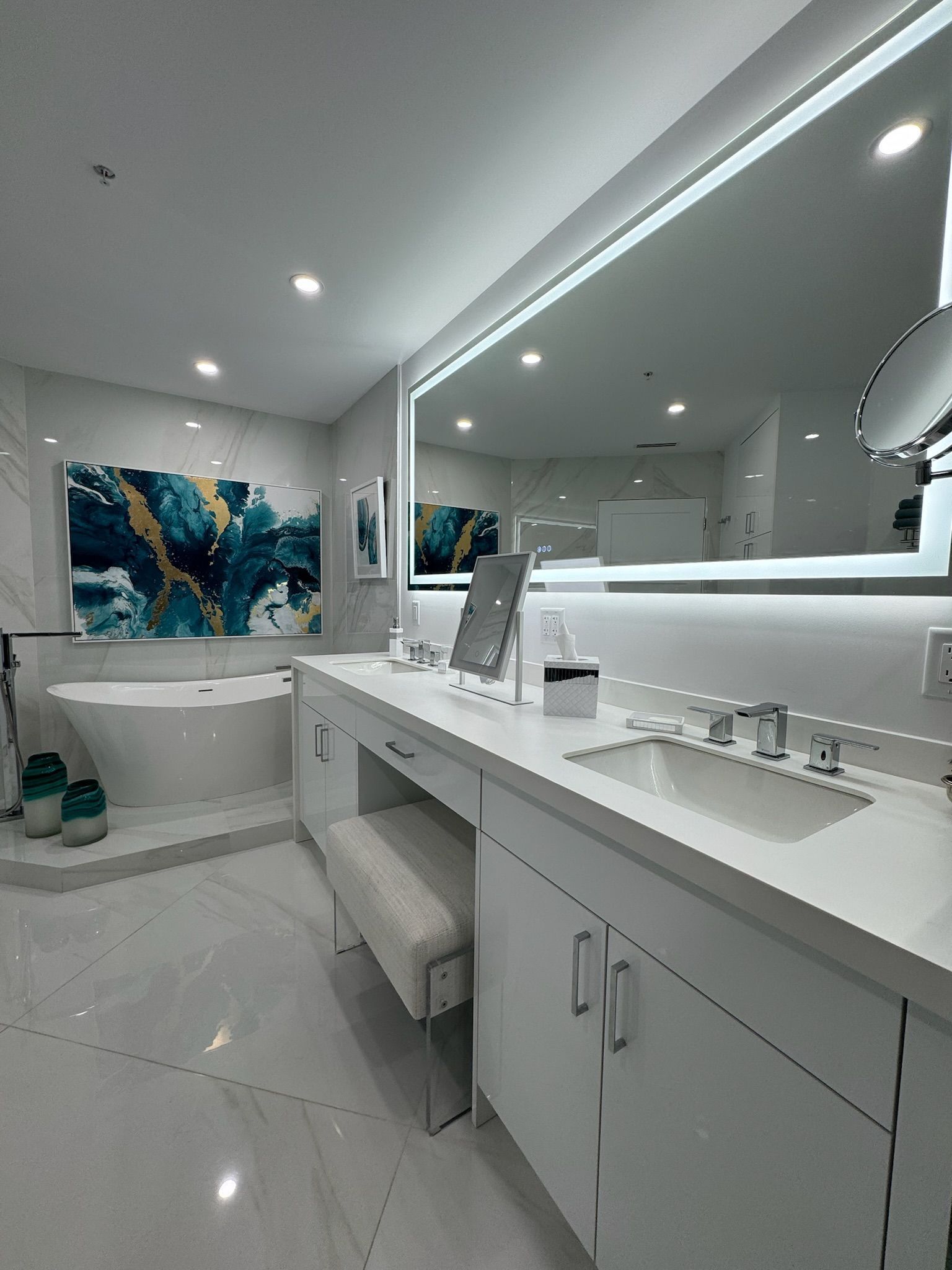A bathroom with a large mirror , sink , and bathtub.