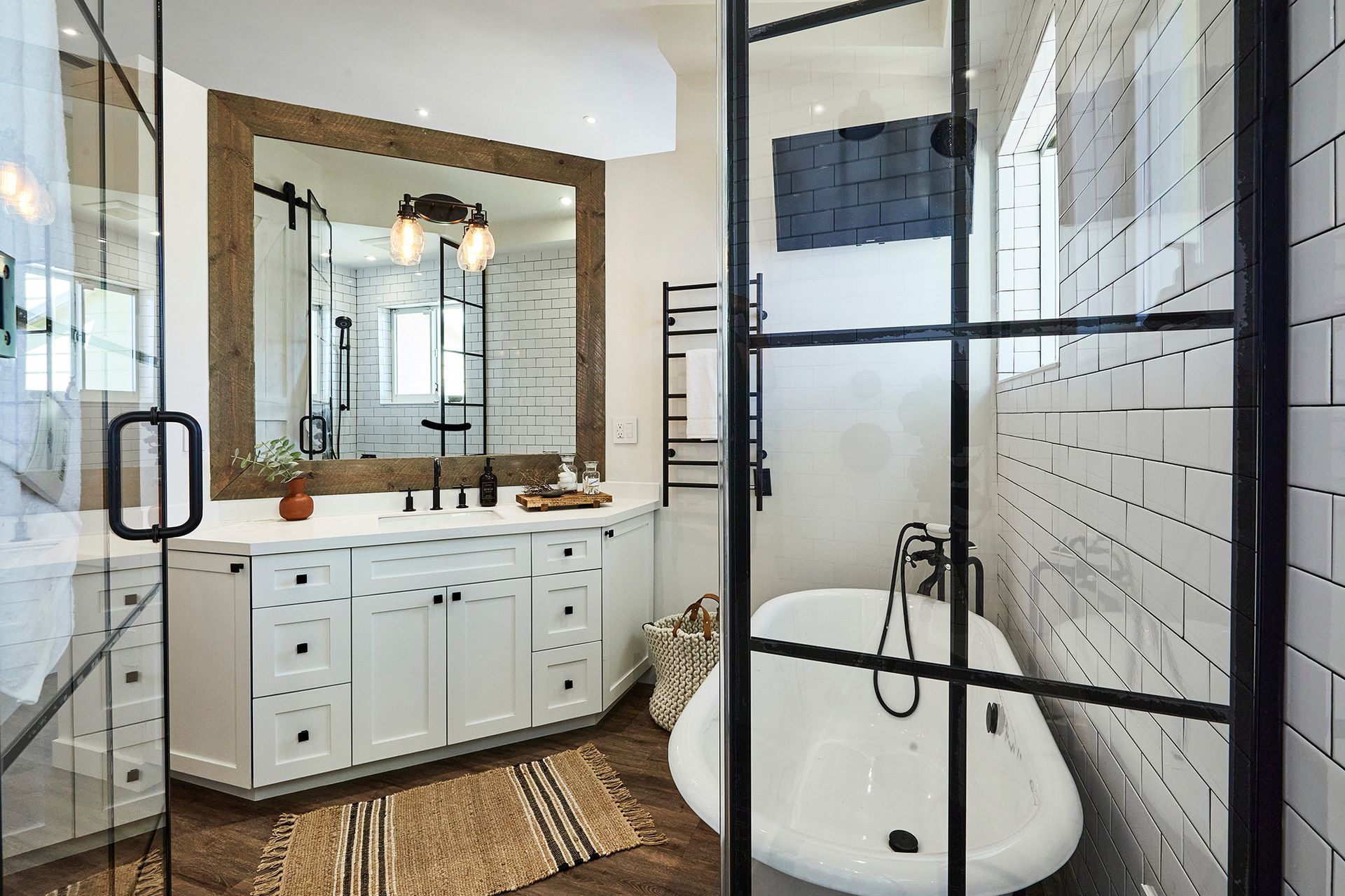 A bathroom with a tub , sink , mirror and walk in shower.