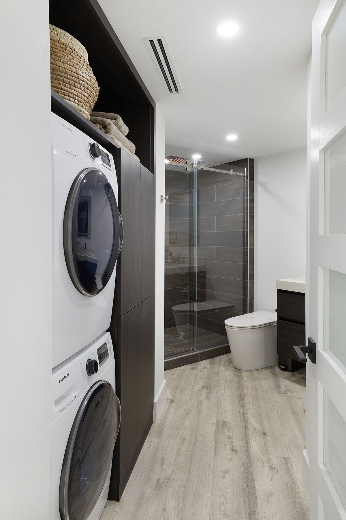 A laundry room with a washer and dryer and a toilet.