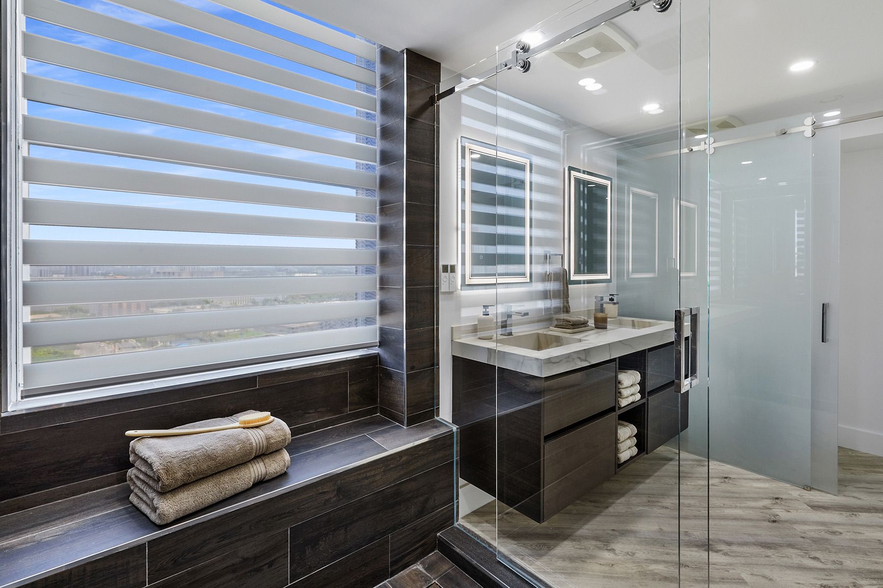 A bathroom with two sinks and a walk in shower.