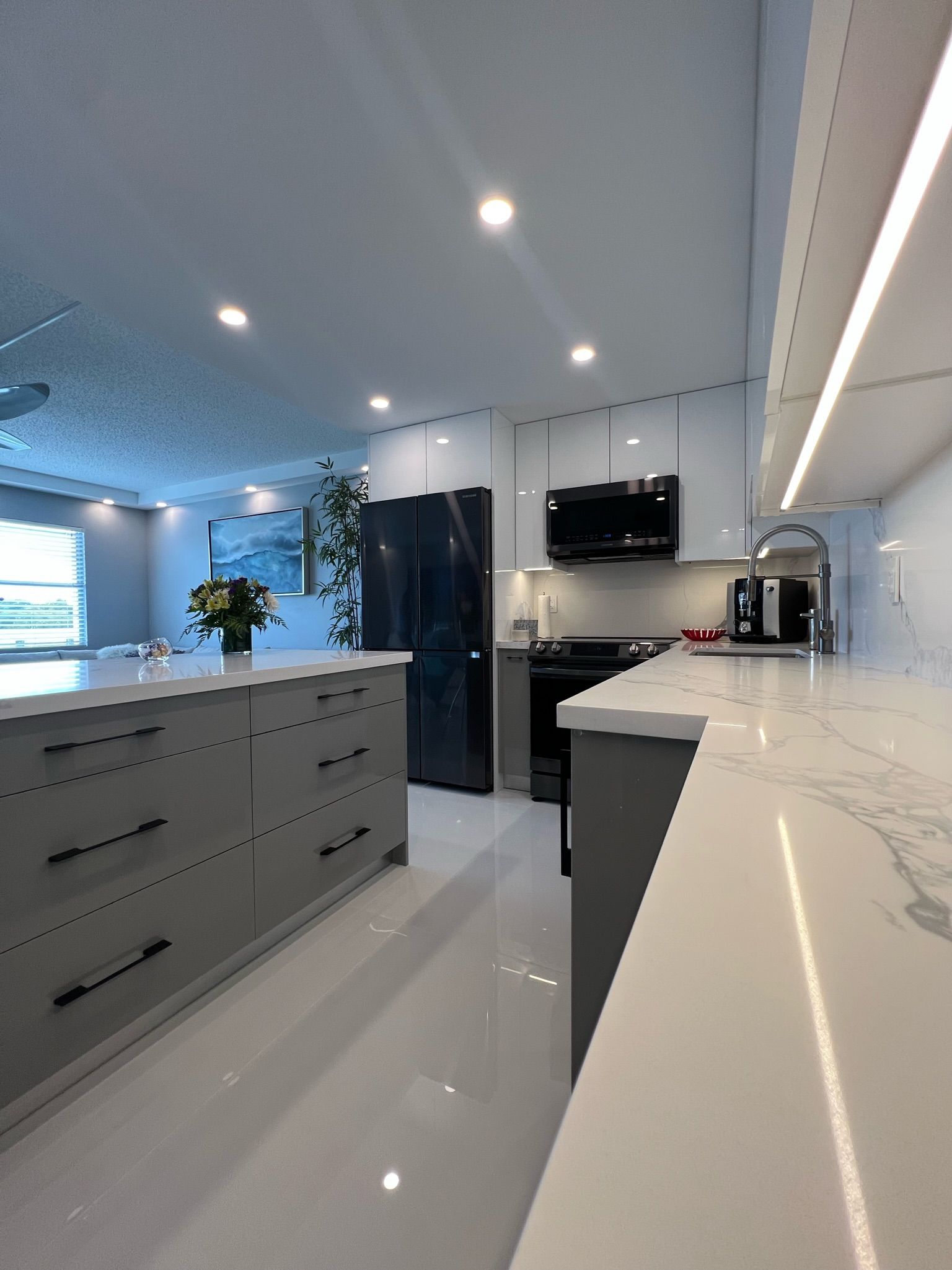 A kitchen with gray cabinets and white counter tops